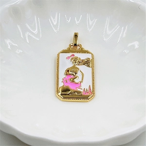 Detail view of a golden tarot pendant featuring a mermaid in pink and white enamel