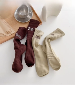 Detail of vintage camping style cotton socks featuring lantern embroidery and ribbed texture