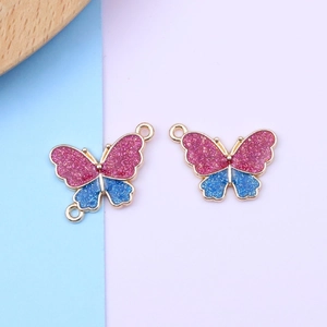 Detail of pink and blue glitter butterfly charms with gold metal frame for DIY jewelry