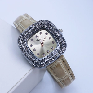 Détail macro d'une montre carrée dorée de luxe avec lunette diamantée et cuir beige