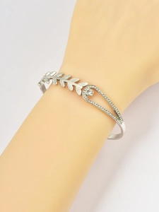 Detailed view of silver wheat leaf bracelet with micro-pave crystals on a model's wrist