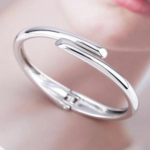 Macro shot of minimalist silver cuff bracelet with polished finish and hinge closure
