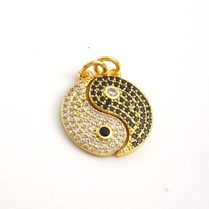 Vue macro du pendentif yin yang avec oxydes de zirconium noirs et blancs dorés à l'or