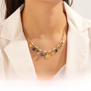 Detail of gold-plated camellia and turquoise heart pendants on a pearl necklace