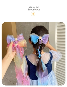 Detail of organza bow hair clip with faux pearls and long tassels on braided hair
