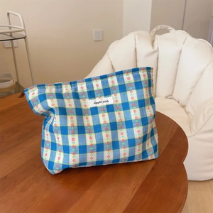 Blue plaid makeup bag with floral print, simple wish label, and metal zipper closure