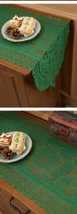 Close-up of green crochet table runner with geometric patterns on a wooden cabinet