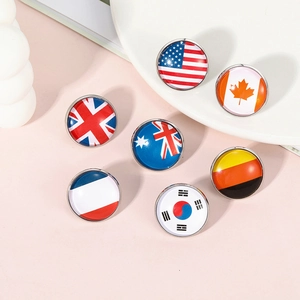 Detailed flat lay of round glass dome flag badges for US UK Canada on pink background