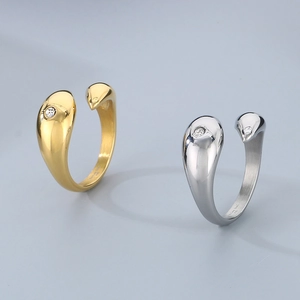 Detailed macro of teardrop shaped open ring with inlaid zircon in gold and silver finish