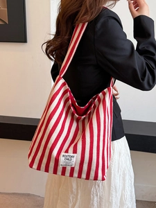 Modern red and white striped canvas tote bag with large capacity shown on a model