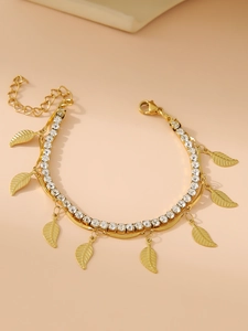 Macro view of gold double-layer bracelet with sparkling zircons and leaf charms
