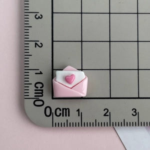 Detailed size view of a 1.5cm pink resin envelope charm for nail art and DIY crafts