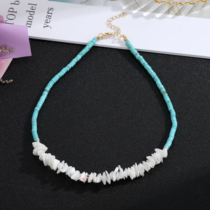 Close-up of bohemian blue turquoise beaded necklace with white shell accents and gold clasp
