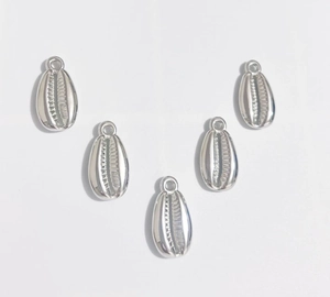Macro shot of five silver CCB seashell pendants with top loops for DIY jewelry making