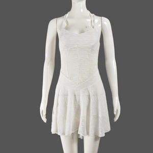 Gros plan sur la robe en dentelle blanche avec motifs floraux et ourlet plissé