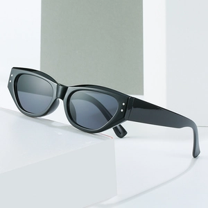 Retro cat-eye sunglasses in glossy black with silver rivets on a geometric display