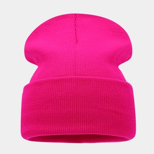 Detailed view of the hot pink knitted beanie with vertical ribbed texture and wide folded cuff