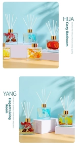 Close-up of square glass diffuser bottle with botanical red berries and pine cones