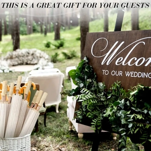 Outdoor wedding display with white paper sun umbrellas in a basket and welcome sign