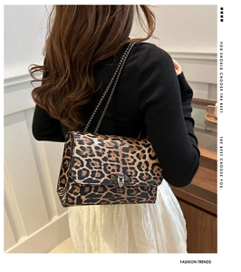 Detail of leopard print bag featuring a gold chain strap and metal stud buckle closure