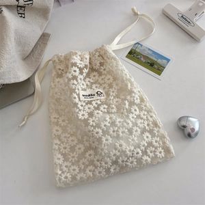 Detail of daisy flower embroidery on white lace mesh drawstring storage bag