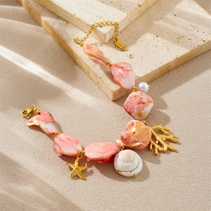 Marine style stainless steel bracelet with pink shell beads and golden sea life charms