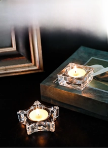 Star and square clear glass tealight candle holders on books for cozy home decor