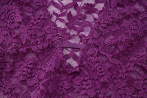 Gros plan sur un tissu en dentelle violette aux motifs floraux complexes et détails en mesh