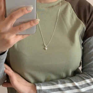 Close-up of a minimalist 925 silver heart pendant necklace worn on a model's neck