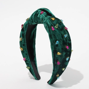 Detail view of dark green velvet knotted headband with colorful rhinestone crystal accents