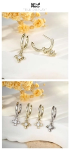 Detail of coffee gold cross earrings with zircon pavé accents and hinged hoop closure