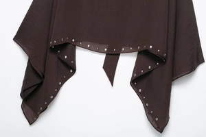 Detail of silver rivets on dark brown fabric edge for a stylish casual women cape top