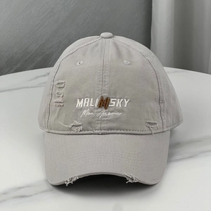 Detail view of grey distressed baseball cap featuring MALINSKY embroidery and torn accents
