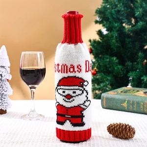 Détail de housse de bouteille de vin tricotée Père Noël sur une table de fête de Noël