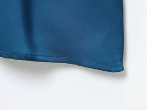 Detailed close-up of dark blue satin dress hem showcasing high-quality silk texture and stitching