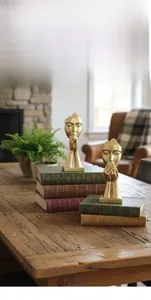 Detail of matte gold abstract sculptures on vintage books with soft lighting and home background