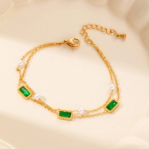 Double-layered gold bracelet with emerald green crystals and elegant white faux pearls