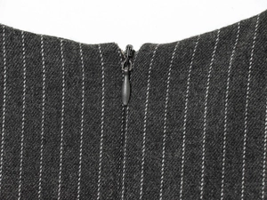 Detail of invisible black zipper on dark gray striped sleeveless midi dress fabric