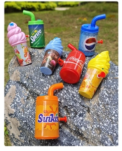 Outdoor macro view of mini water guns shaped like soft drink cans and ice cream cups