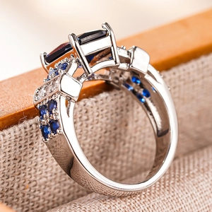 Macro view of a square sapphire ring with intricate hollow prongs and vintage silver plating