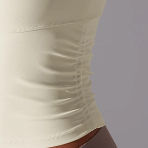 Détail des fronces sur le débardeur de yoga crème montrant la qualité du tissu