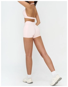Pink yoga set featuring a halter sports bra and high-waisted shorts with moisture-wicking fabric
