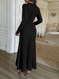 Detail of elegant black short sleeve knit maxi dress showing open back design and A-line hem
