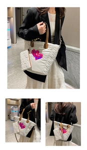 Detail der weißen gesteppten Puffer-Tasche mit rosa Herz-Patches und Lederriemen