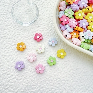 Close-up of colorful flower acrylic beads for DIY jewelry making in a beige bowl