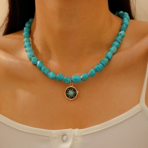 Bohemian turquoise beaded necklace with golden sun pendant on a female model