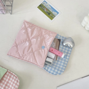 Detail of pink quilted patent leather pouch with light blue checkered fabric lining
