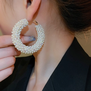 Detailed close-up of C-shaped hoop earrings with faux pearls and colorful rhinestones