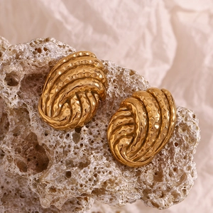 Macro view of 18K gold-plated titanium steel earrings with a hammered button texture