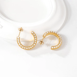 Elegant gold plated C-shaped earrings with double rows of inlaid white pearls on white tray
